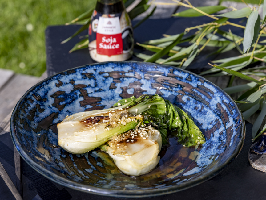 Pokrm Pak choi servírovaný na hlubokém černo modrém talíři.