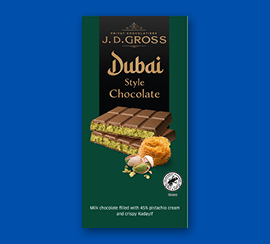 Čokoláda v dubajském stylu v tmavě zeleném balení na modrém pozadí